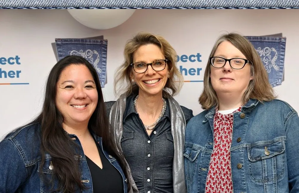 Three members of the Transitions of PA development team standing together at a Respect Together event.